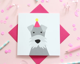 May include: A white card with a gray dog wearing a pink and yellow party hat. The card is on a pink background with pink confetti and a pink envelope.