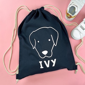 May include: Black drawstring bag with a white outline of a dog's head and the name "IVY" printed below.