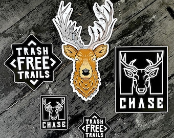Könnte beinhalten: Fünf schwarz-weiße Aufkleber mit einem Hirschkopf-Design. Zwei der Aufkleber sagen "Trash Free Trails" in einer Sternform. Ein Aufkleber sagt "CHASE" mit einem Hirschkopf-Design. Zwei Aufkleber haben ein Hirschkopf-Design mit dem Wort "CHASE" darunter.