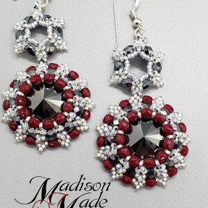 May include: A pair of silver dangle earrings with a red and silver beaded design. The earrings feature a large, faceted black crystal in the center of each earring.