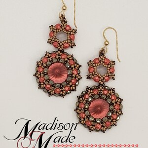 May include: A pair of dangle earrings with a gold hook and two tiers of beads. The top tier is a starburst shape with coral-colored beads. The bottom tier is a round shape with coral-colored beads and a clear crystal in the center. The earrings are accented with gold-colored beads.