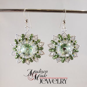 May include: A pair of silver earrings with green and clear crystal beads in a floral design.