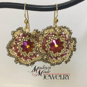 May include: Gold earrings with a pink crystal center and a beaded design. The earrings are in the shape of a flower.