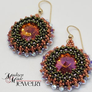 Puede incluir: Un par de pendientes de cuentas con un dise&ntilde;o redondo multicolor. Los pendientes presentan un gran cristal naranja facetado en el centro de cada pendiente. Los pendientes est&aacute;n hechos con cuentas de cobre, verdes y moradas.