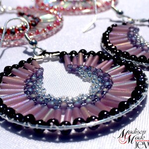 May include: A pair of hoop earrings with a silver wire base and a design of purple and black beads. The beads are arranged in a fan shape, with the purple beads on the outside and the black beads on the inside.
