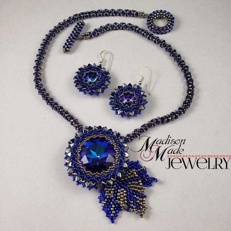 May include: A blue and silver beaded necklace with a large blue crystal pendant and matching earrings. The necklace is made with a delicate chain and the pendant is a large, round crystal with a silver setting. The earrings are small and round with a silver setting and a blue crystal.
