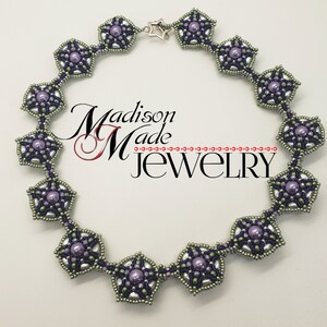 May include: A silver and purple beaded necklace with a star charm. The necklace is made of small, round beads and features a repeating pattern of star-shaped motifs. The necklace is approximately 18 inches long.
