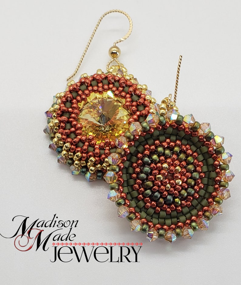Puede incluir: Un par de pendientes de cuentas con un acabado dorado. Los pendientes presentan un dise&ntilde;o redondo multicolor con un centro de cristal. Los pendientes est&aacute;n hechos a mano y tienen un estilo &uacute;nico y bohemio.