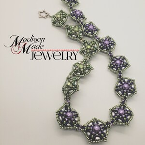 May include: A delicate necklace with a geometric design featuring alternating green and purple star-shaped beads. The necklace is made with small seed beads and larger pearl-like beads.