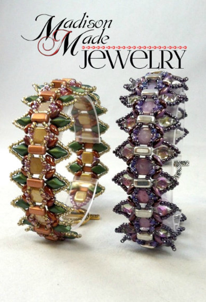 May include: Two beaded bracelets. One bracelet features green, gold, and brown beads in a geometric pattern. The other bracelet has purple and silver beads. The bracelets are displayed on clear stands. The text "Madison Made Jewelry" is at the top.
