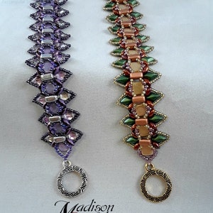 May include: Two beaded bracelets with intricate designs. One is purple with silver accents, the other is green, gold, and copper. Both have decorative clasps. The text "Madison Made Jewelry" is at the bottom.