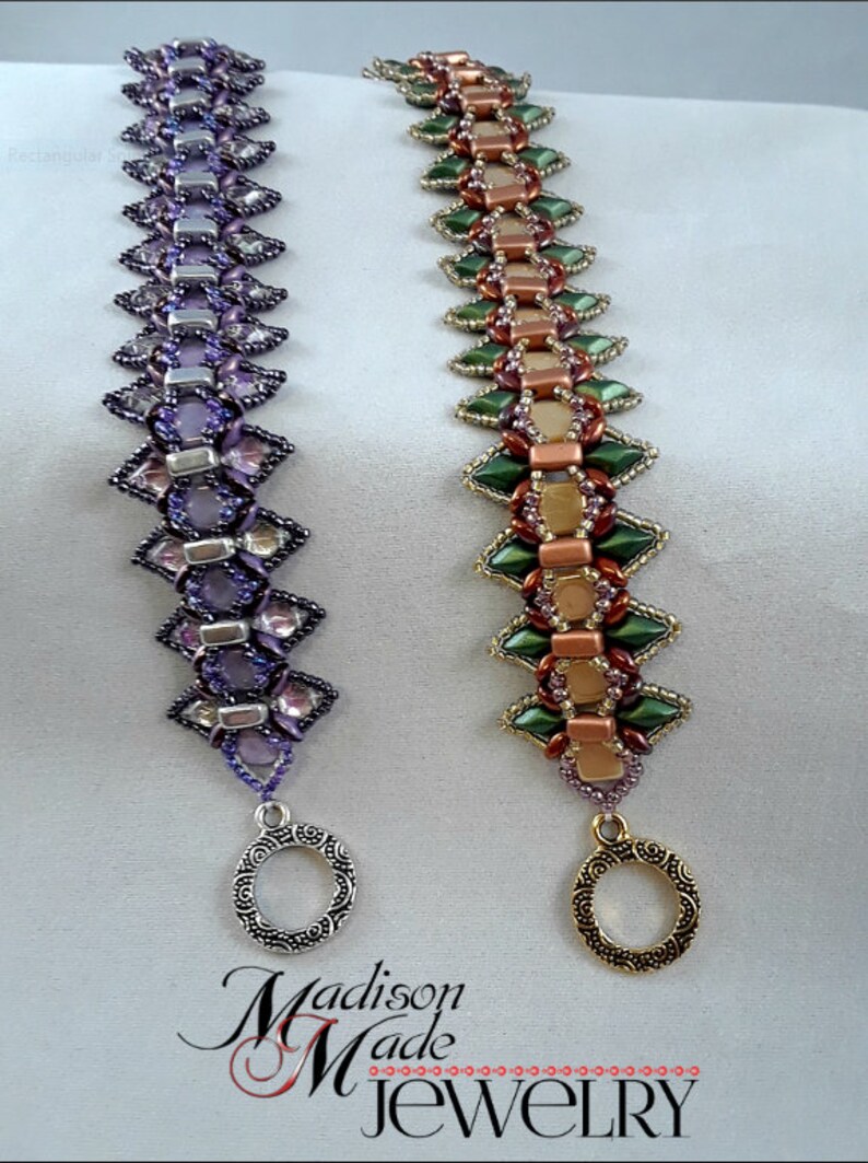 May include: Two beaded bracelets with intricate designs. One is purple with silver accents, the other is green, gold, and copper. Both have decorative clasps. The text "Madison Made Jewelry" is at the bottom.