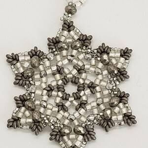 May include: A silver and gray beaded snowflake ornament with a loop for hanging.