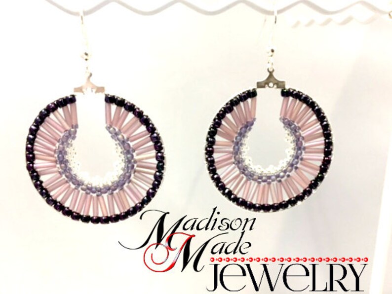 May include: A pair of hoop earrings with a layered design of pink, purple, and black beads. The earrings are made with silver hooks.