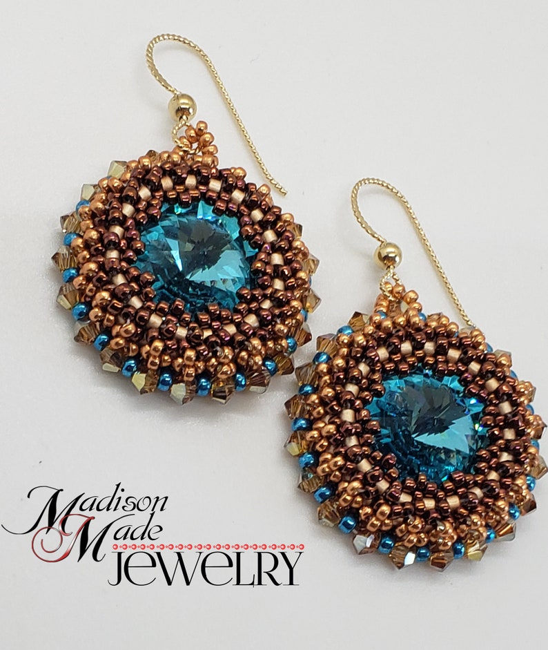 Puede incluir: Un par de pendientes de oro con un cristal azul turquesa rodeado de cuentas marrones y doradas.