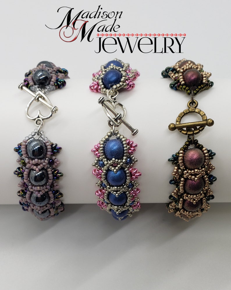 May include: Three beaded bracelets with different colored beads and clasps. The bracelets are made with silver, gold, and dark grey beads. The clasps are silver, gold, and silver.