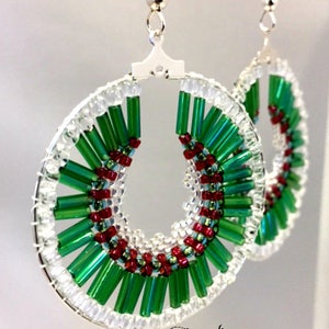May include: A pair of green and red beaded hoop earrings with silver hooks. The beads are arranged in a spiral pattern.