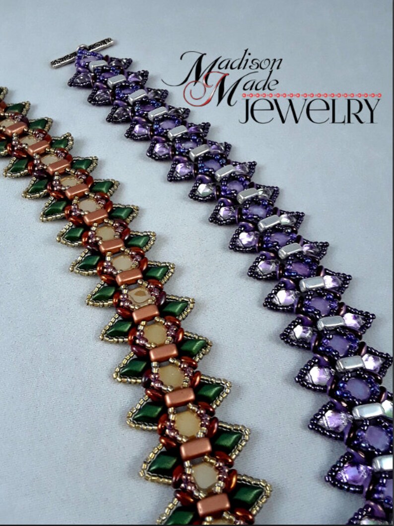 May include: Two beaded bracelets in a zig-zag pattern. One bracelet features green, gold, and brown beads. The other bracelet is purple and silver. The bracelets are handmade and the text "Madison Made Jewelry" is in the background.