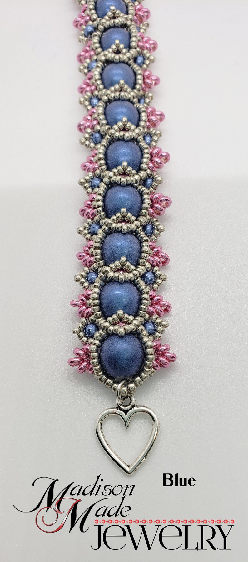 May include: A blue beaded bracelet with silver and pink beads. The bracelet has a heart charm and the text "Madison Made Jewelry" and "Blue" on the bottom.