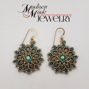 May include: A pair of handmade earrings with a floral design. The earrings feature a central teal bead surrounded by copper, blue, and green beads. The earrings are suspended from gold-colored ear wires. The text "Madison Made Jewelry" is in the upper left.