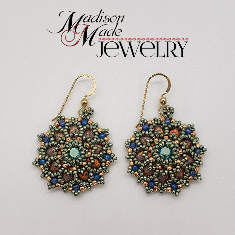 May include: A pair of handmade earrings with a floral design. The earrings feature a central teal bead surrounded by copper, blue, and green beads. The earrings are suspended from gold-colored ear wires. The text "Madison Made Jewelry" is in the upper left.