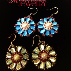 May include: Two pairs of flower-shaped earrings. The first pair is blue with a white pearl center and red accents. The second pair is green with a beige center and red accents. Both pairs have gold hooks.
