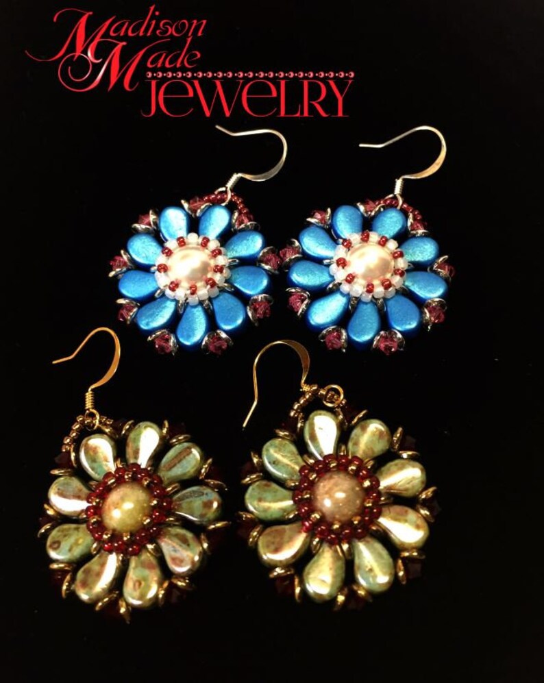 May include: Two pairs of flower-shaped earrings. The first pair is blue with a white pearl center and red accents. The second pair is green with a beige center and red accents. Both pairs have gold hooks.
