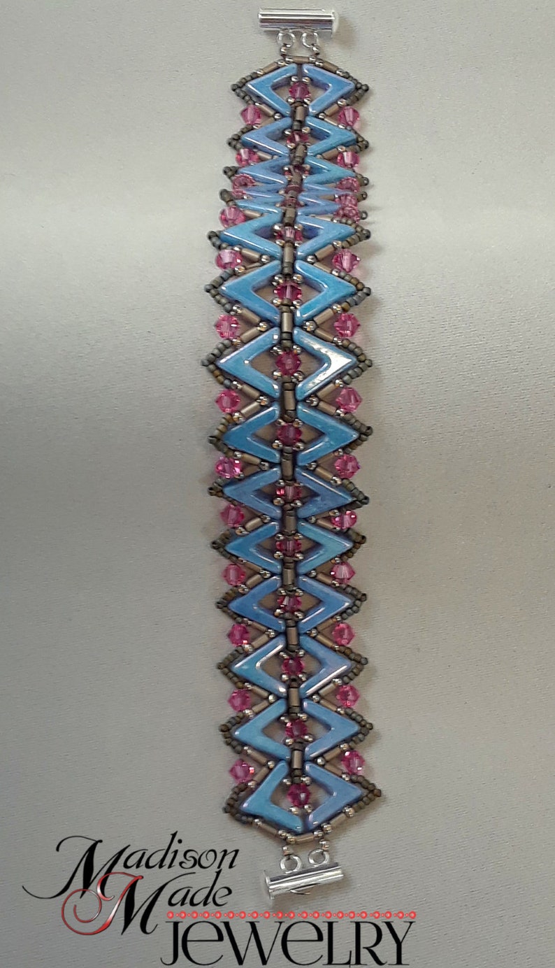 May include: A blue and pink beaded bracelet with a silver clasp. The bracelet is made with small, faceted beads in a geometric pattern.