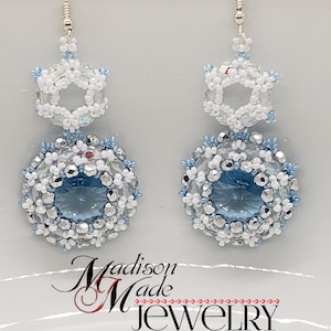 May include: A pair of silver snowflake earrings with blue and white crystal beads. The earrings are made by Madison Made Jewelry.