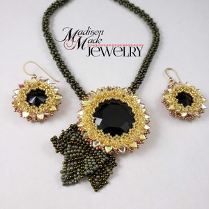 May include: A black and gold beaded necklace with a large black gemstone pendant and matching earrings. The necklace features a green beaded chain and a bow-shaped pendant. The earrings are small and round with a black gemstone center.
