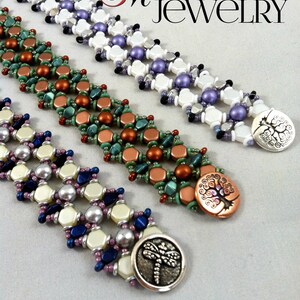 Op de afbeelding: Drie kralenarmbanden met kralen in verschillende kleuren en decoratieve metalen sluitingen. De sluitingen tonen een boom, een libel en een boom met spiralen. De armbanden zijn gelabeld met "Madison Made Jewelry".