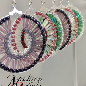 May include: A set of four pairs of earrings with a spiral design. The earrings are made of silver and glass beads in shades of pink, purple, green, and white. The earrings are hanging from a white background.