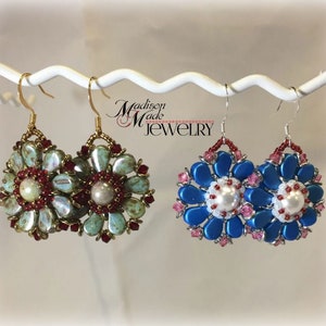 May include: Two pairs of beaded earrings, one pair is blue and white with a pearl center, the other pair is green and red with a pearl center. The earrings are hanging from a white display stand. The text "Madison Made Jewelry" is visible in the background.