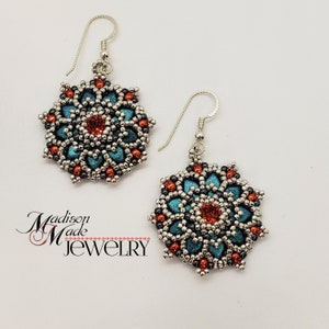 May include: A pair of handmade earrings with a floral design. The earrings feature teal, orange, and silver beads, with a red center stone. The earrings are suspended from silver hooks. The text "Madison Made Jewelry" is in the lower left corner.