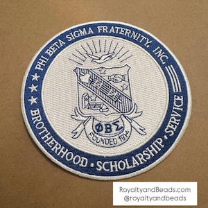 May include: A circular patch with a white background and a blue border. The patch features the text "PHI BETA SIGMA FRATERNITY, INC." and "BROTHERHOOD • SCHOLARSHIP • SERVICE." A crest with a dove, stars, and the letters "ΦΒΣ" is in the center.