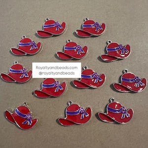 May include: Twelve red and silver charm pendants shaped like hats with purple ribbon and flower accents. Royaltyandbeads.com @royaltyandbeads