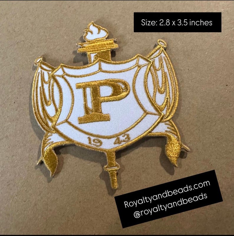 May include: Embroidered patch featuring a white shield with a gold border and accents. The shield displays a gold "P" and the year "1943". The patch measures 2.8 x 3.5 inches and includes the text "Royaltyandbeads.com".