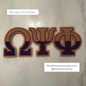 May include: Three embroidered Greek letters, Omega, Psi, and Phi, in a collegiate style. The letters are purple with gold textured accents and a tan border. The size is about 10 x 4 inches.