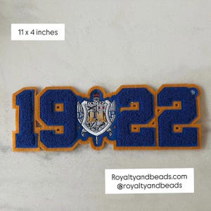 May include: A blue and gold patch with the numbers "1922" and a crest in the center. The patch measures 11 x 4 inches. The text "Royaltyandbeads.com" and "@royaltyandbeads" are at the bottom.