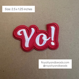May include: Red embroidered patch with the word "Yo!" in white script. The patch measures 2.5 x 1.25 inches. The patch has a red border and is on a tan background. The text "Royaltyandbeads.com @royaltyandbeads" is also visible.