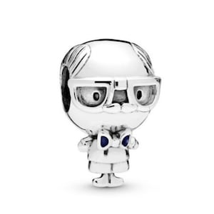 Può includere: Ciondolo in argento con un personaggio dei cartoni animati con occhiali, papillon e testa calva.