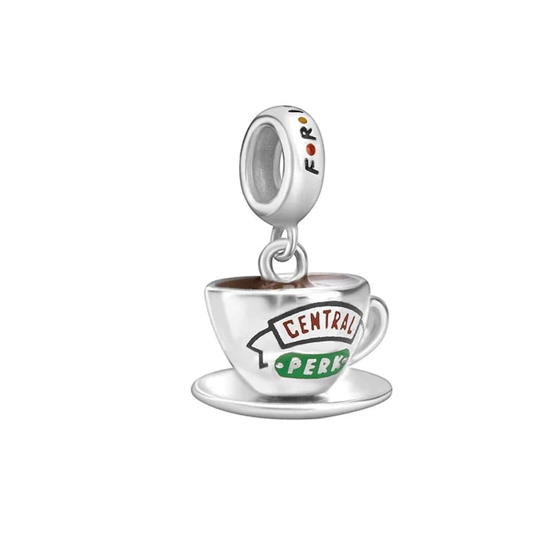 May include: Silver charm featuring a coffee cup with the words "Central Perk" on it. The charm has a small loop at the top for attaching to a bracelet or necklace.