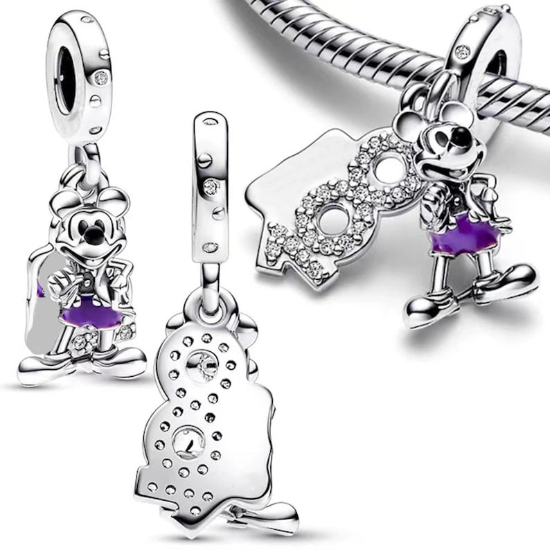May include: Three silver charm beads featuring Mickey Mouse. One bead shows Mickey Mouse in a purple outfit, another bead shows Mickey Mouse with the number 90, and the third bead shows Mickey Mouse with the number 90 with a sparkly design.