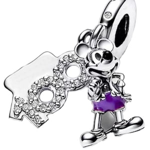 May include: Silver charm featuring Mickey Mouse in his iconic red shorts and purple shirt, holding a silver charm with the number "90" adorned with clear cubic zirconia stones.