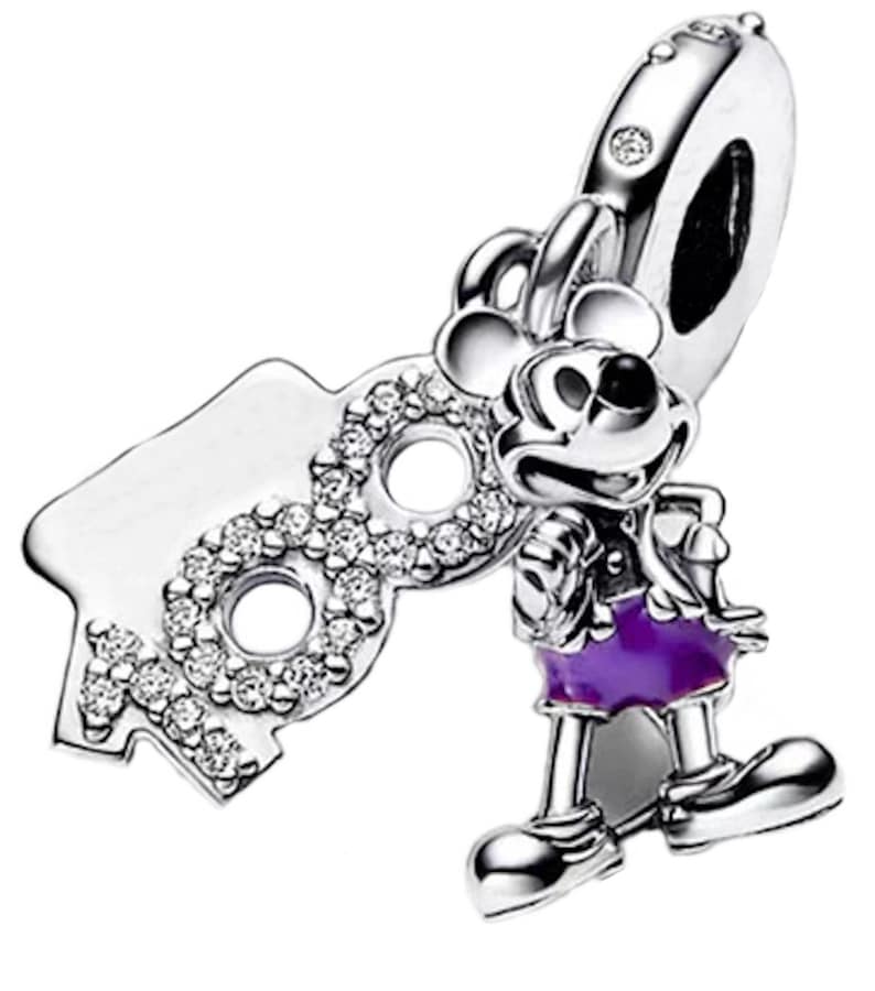 May include: Silver charm featuring Mickey Mouse in his iconic red shorts and purple shirt, holding a silver charm with the number "90" adorned with clear cubic zirconia stones.