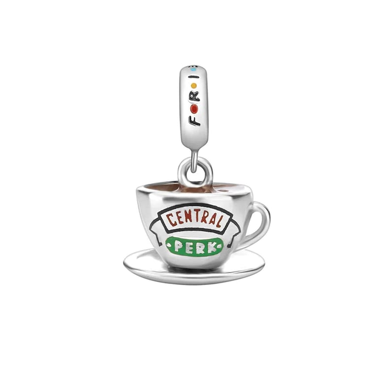 May include: Silver charm featuring a coffee cup and saucer with the words "Central Perk" in green and red lettering.