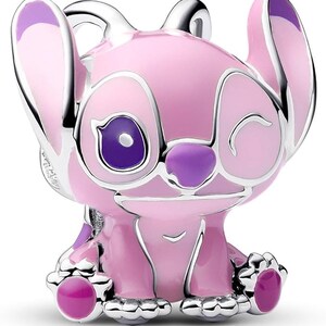 May include: A pink and purple charm featuring a cartoon character with large ears and a winking expression. The charm has a silver-colored outline and accents, with a glossy finish. The character's eyes, nose, and feet are a darker shade of purple.