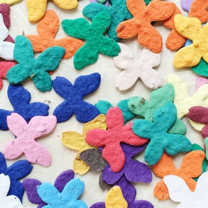 Puede incluir: Surtido de flores de papel de colores en varias formas y tama&ntilde;os. Las flores est&aacute;n hechas de papel fino y delicado y tienen una textura ligeramente arrugada. Los colores incluyen rosa, azul, morado, verde, rojo, naranja, amarillo y blanco.