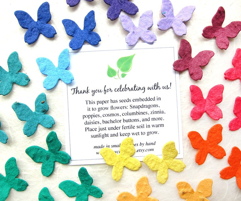 Puede incluir: Surtido de mariposas de papel de colores con semillas incrustadas. Las mariposas est&aacute;n hechas de papel reciclado y se pueden plantar para hacer crecer flores. La tarjeta dice: "&iexcl;Gracias por celebrar con nosotros! Este papel tiene semillas incrustadas para hacer crecer flores: Boca de drag&oacute;n, amapolas, cosmos, aguile&ntilde;as, zinnias, margaritas, botones de oro y mucho m&aacute;s. Coloque las semillas justo debajo de la tierra f&eacute;rtil en un lugar c&aacute;lido y soleado y mant&eacute;ngalas h&uacute;medas. Hecho en peque&ntilde;as cantidades a mano. .etsy.com"