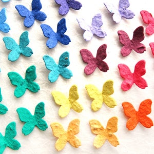 Puede incluir: Surtido de mariposas de papel de colores en varios tonos de azul, verde, amarillo, naranja, rojo y morado. Las mariposas est&aacute;n hechas de papel reciclado y son perfectas para agregar un toque de fantas&iacute;a a cualquier proyecto artesanal.